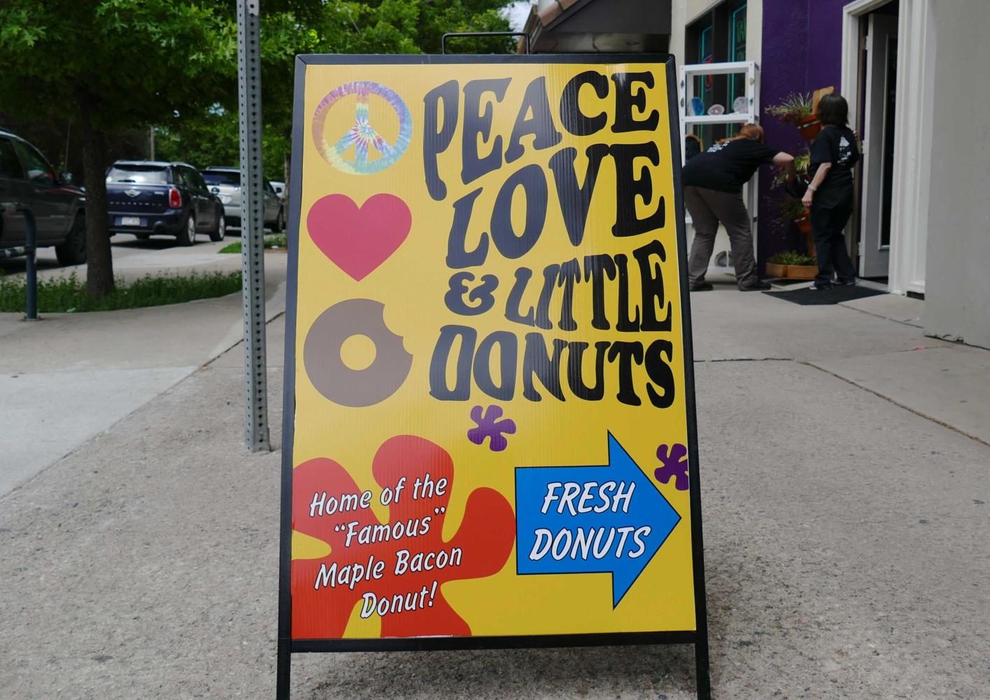 A sign in front of the Peace, Love, and Little Donuts storefront advertises the newly opened business. Peace, Love, and Little Donuts recently opened at 632 College Avenue.