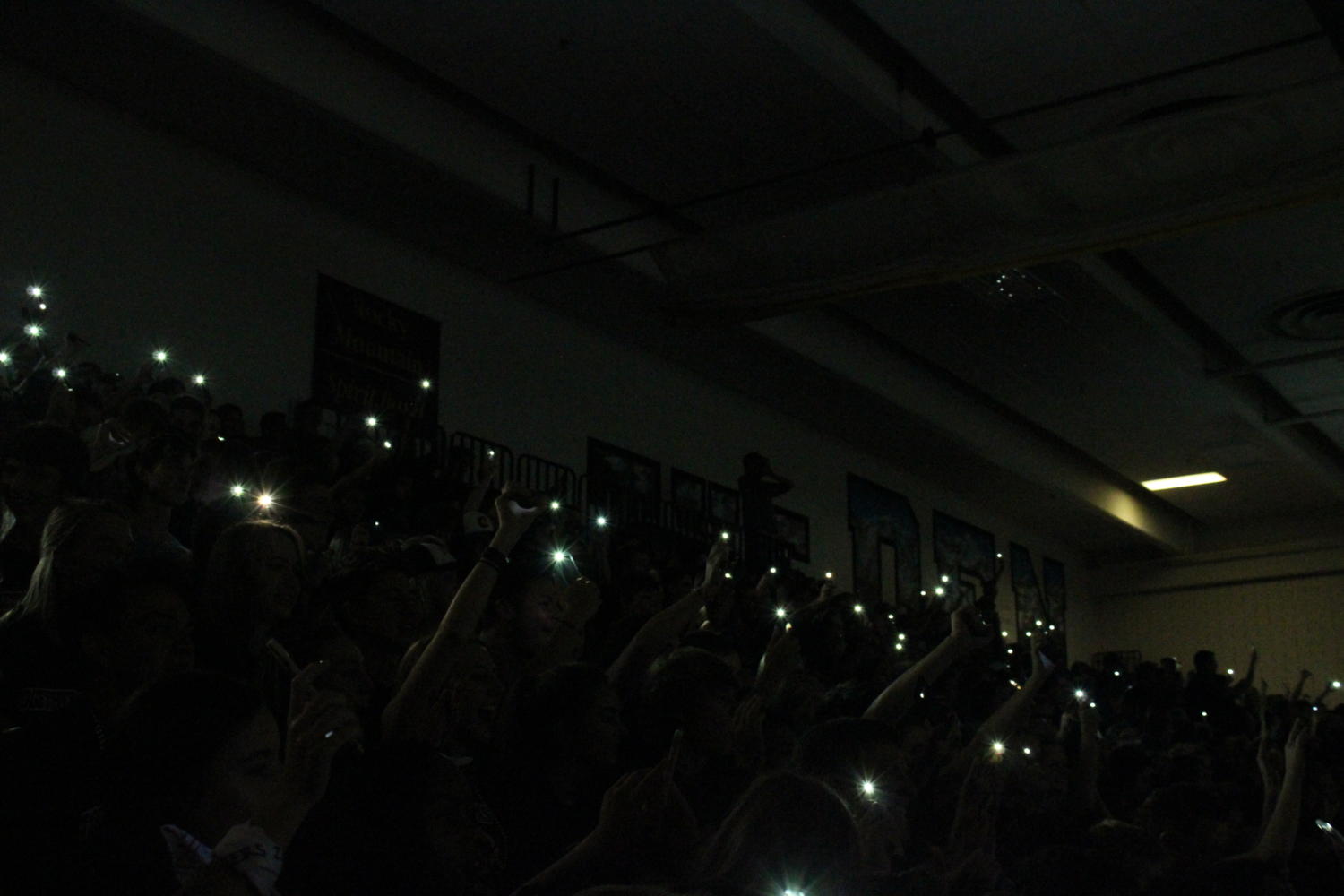 Rocky students shining their flashlights at the back to school assembly.