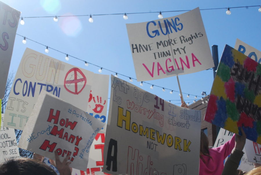 Signs held up in the air with many different messages requesting gun control, on Tuesday afternoon at the walk out.