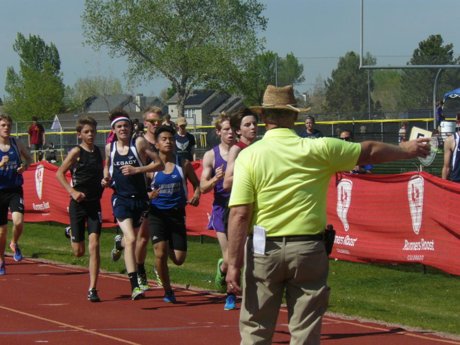Runners, including freshman Niall Kaines, race the 1600 meters with direction from a meet official. Rocky competed in their last track meet before state May 10 at Fort Collins High School.