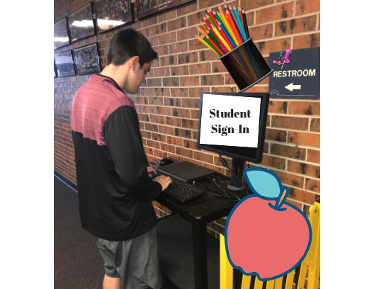 Senior Seth Bass looks at the new sign-in system because he is late to class. 