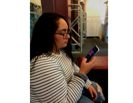 This student plays a game  on her phone while at school, as do many students.