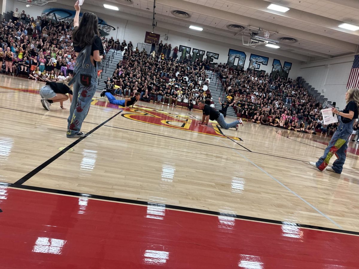 Dr. Woodall does "The Worm" with his kids Nathan (12th) and Avery (9th) Woodall at the Back to School assembly. 