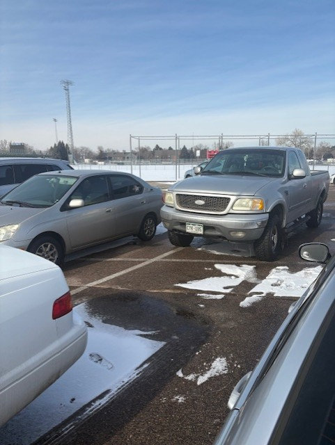 The school parking lot gets full fast and people park outside the lines often. 
