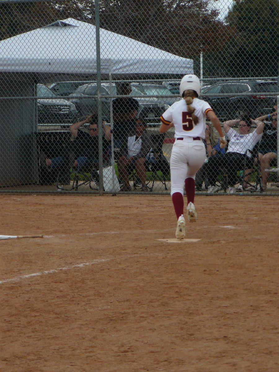 Ellie Eliason (senior) makes it to home base, adding another point on the scoreboard against Riverdale Ridge.