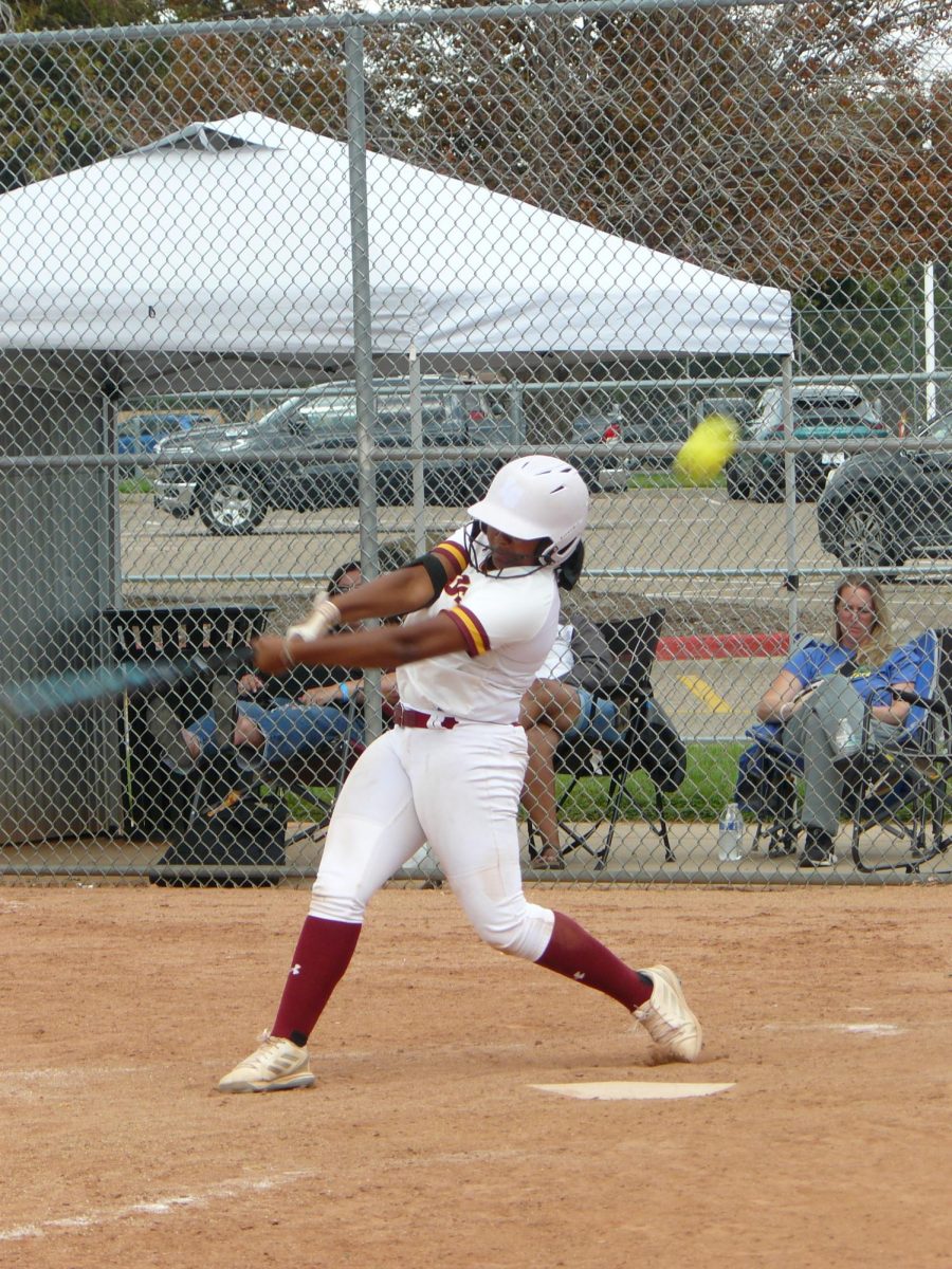 Varsity player Ari Jackson (senior) swings and misses the ball for a strike in a game against Thunder Ridge High School. 