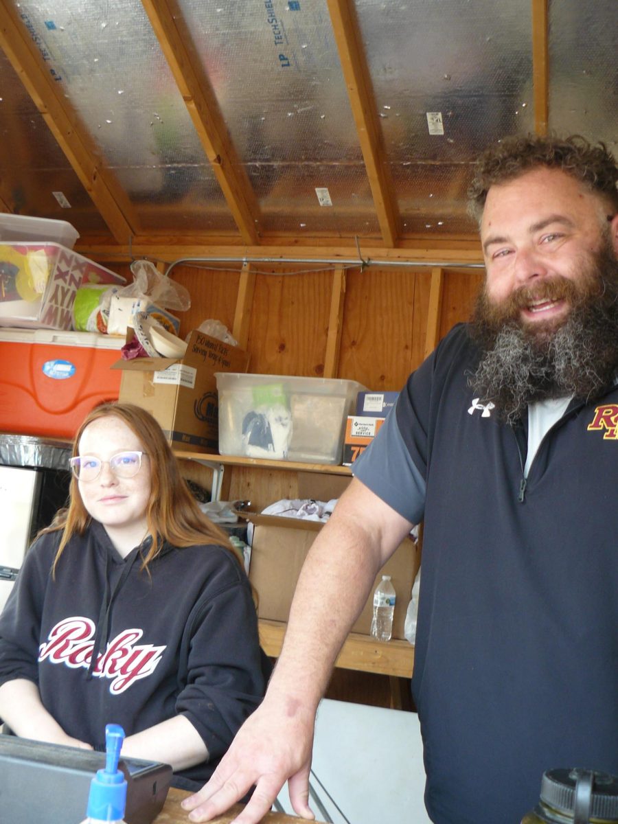 Adrian Flygt announces for the softball games while student team manager Brianna Osborn works the scoreboard. Mr. Flygt has done announcing for Rocky softball for 10 years!