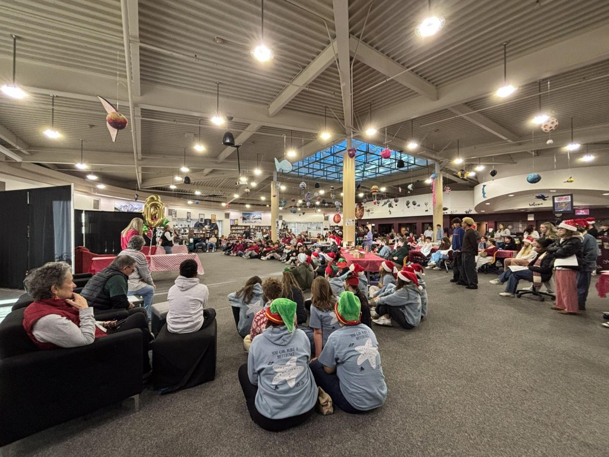 Volunteers listening to Jessica Waters give opening speech for the 30th anniversary of Adopt-A-Family.