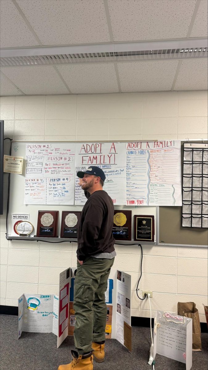 Mr. Thompson goes over Adopt a Family information with his class. Adopt a Family was one of the many extra things teachers do to help the Rocky community. 