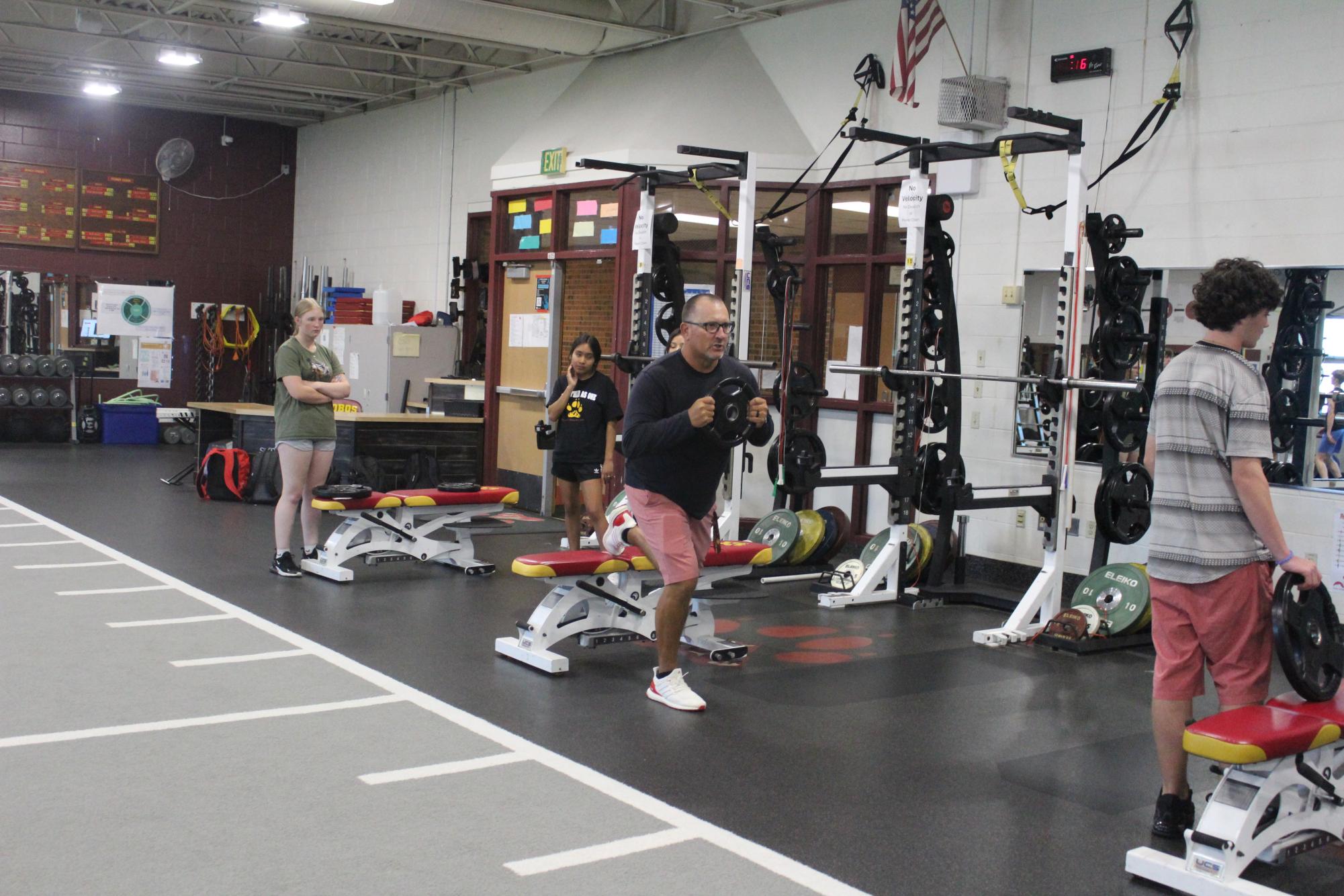 Mr. Bullock demonstrates an exercise in the weight room. Many students used the weight room to stay in shape and feel their best. 